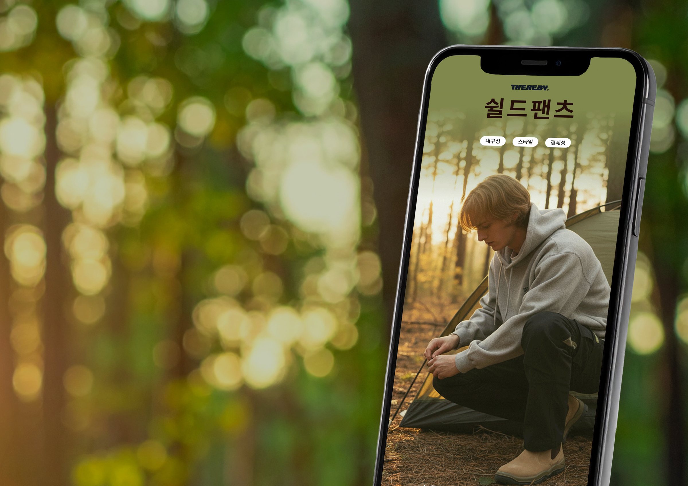 The Thereby Shield Pants landing page cover on a phone, against a sunlit pine forest