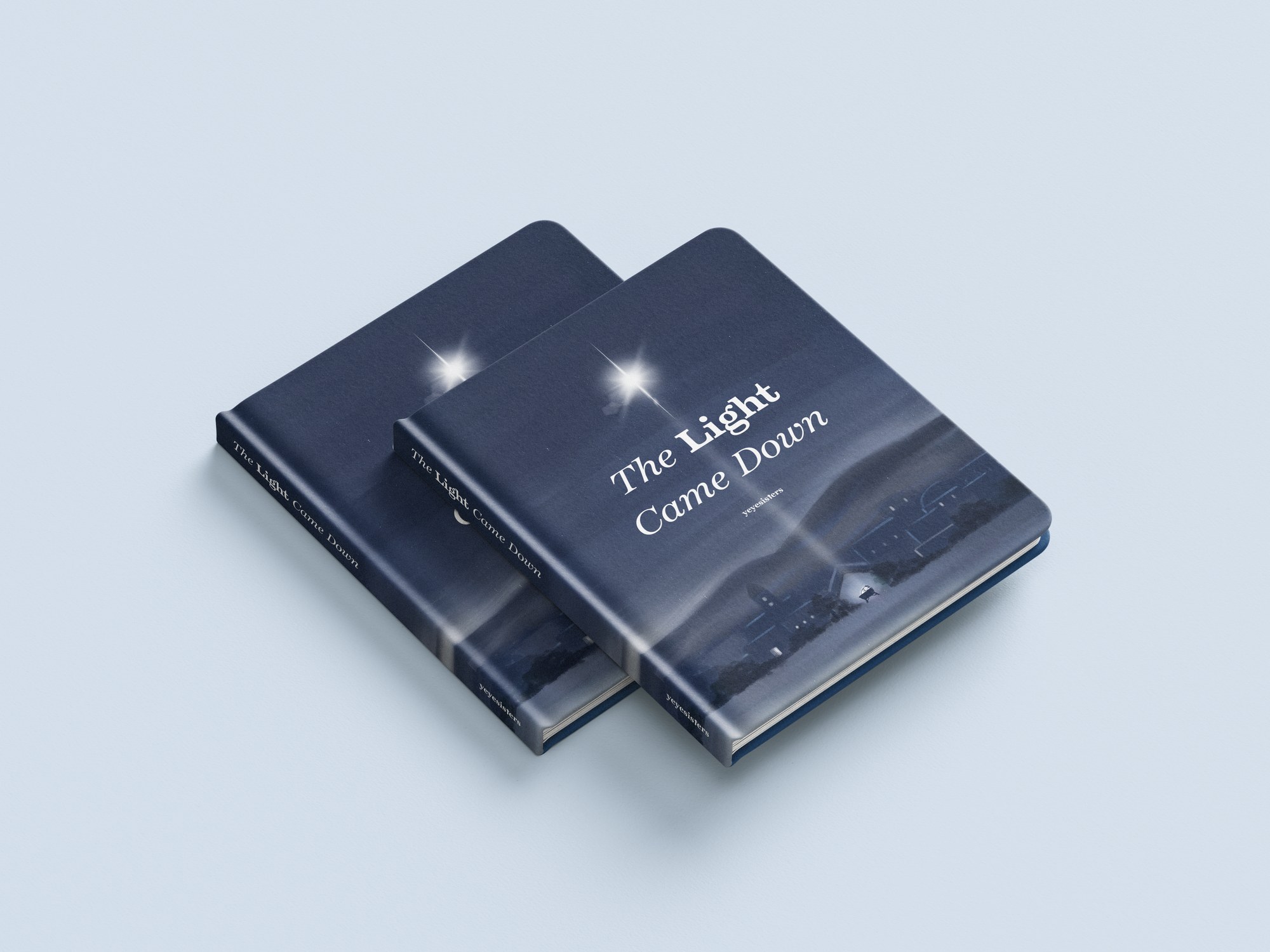 Two copies of The Light Came Down, navy covers with a bright star over a sleeping town